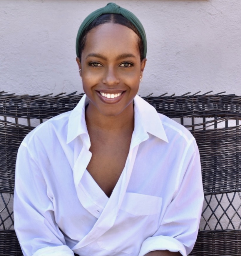 A woman sitting on top of a chair wearing a white shirt.