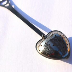 A spoon with a heart shaped mirror on it.