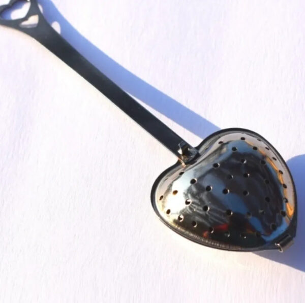 A spoon with a heart shaped mirror on it.
