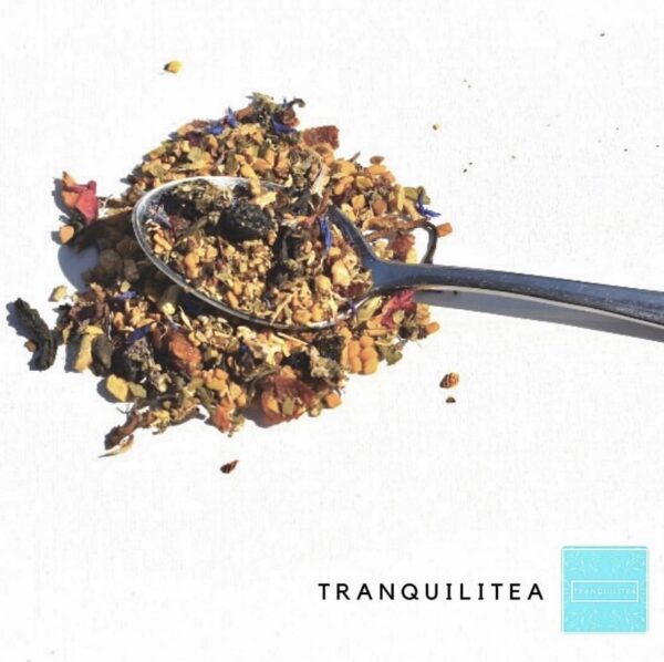 A spoon is on top of granola and tea.